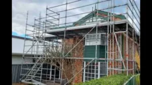 Scaffolding around a brick house for renovation.
